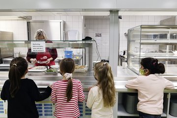 Die Kinder holen sich Frühstück am Buffet