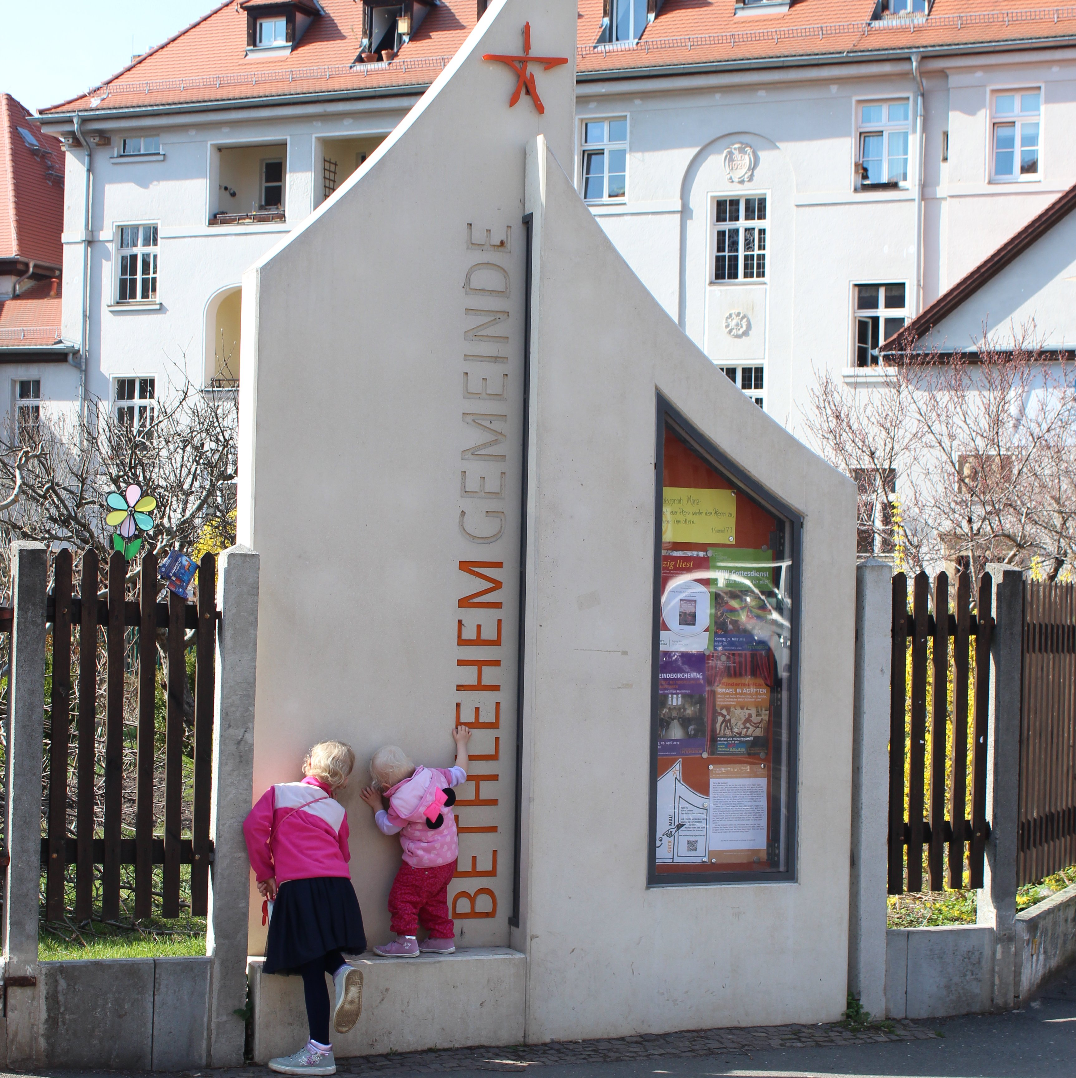 Zwei Kinder gucken in ein Loch in der Wand