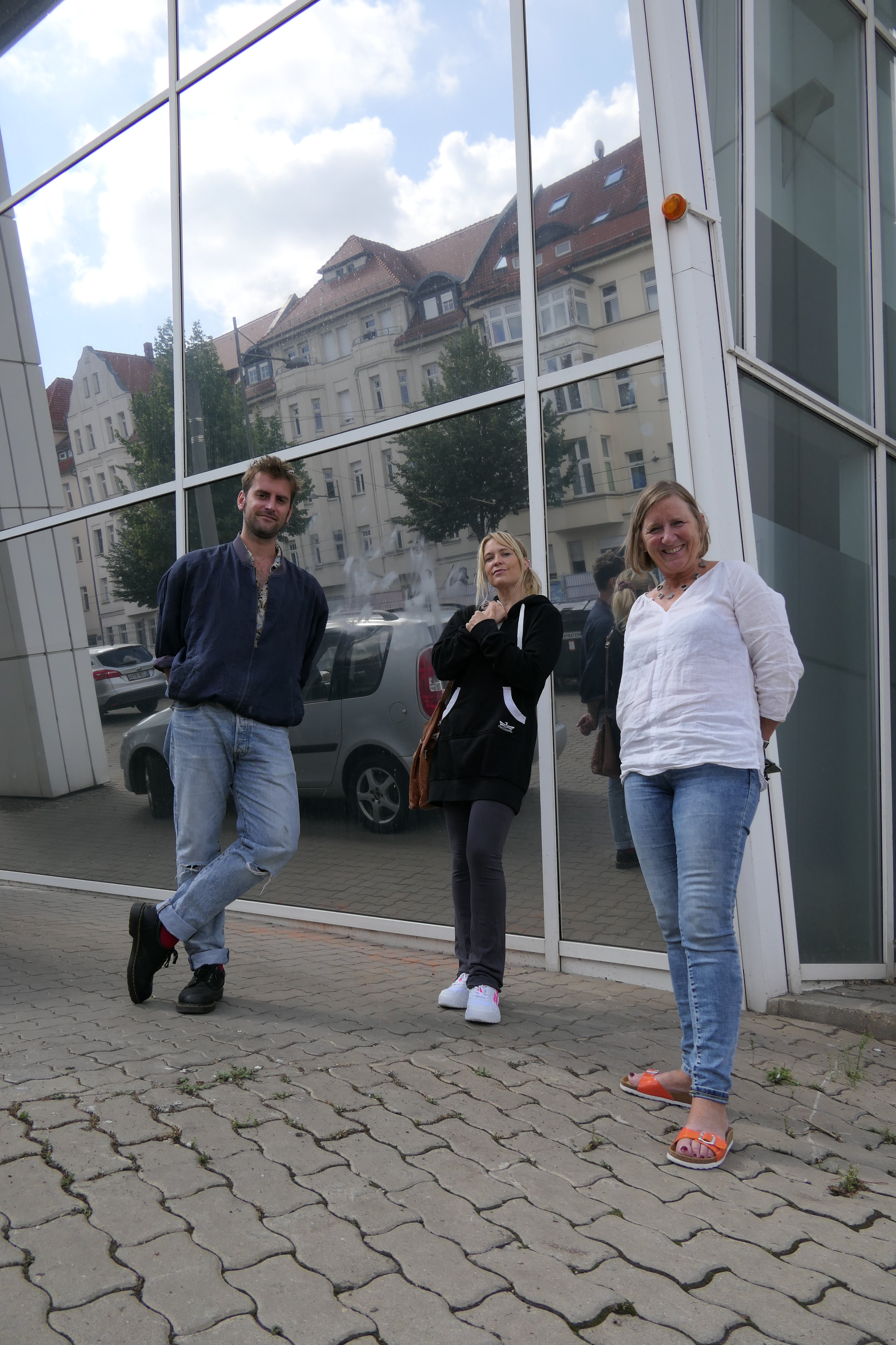 Drei Personen vor einer Glasfront