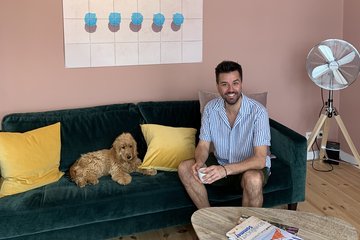 Ein Mann auf einem Sofa, neben ihm ein Hund