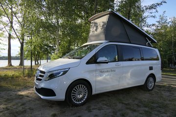 Ein weißer Mercedes Benz Van mit Dachaufsatz