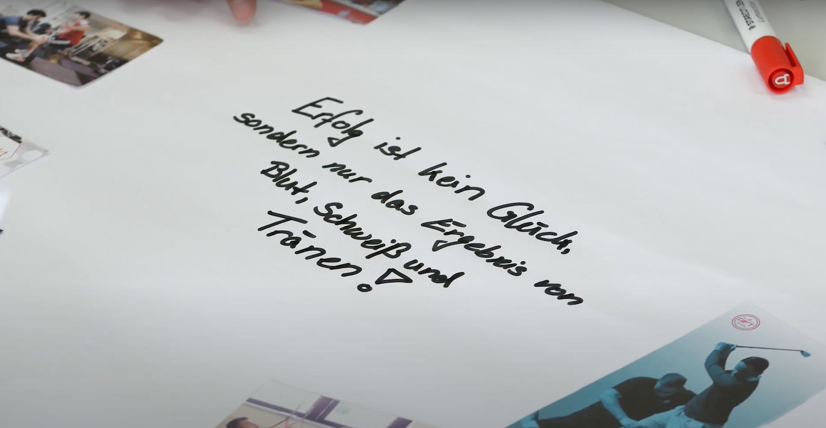 Ein Blatt Papier auf dem mit schwarzem Filzstift der Text "Erfolg ist kein Glück, sondern nur das Ergebnis von Blut, Schweiß und Tränen!" geschrieben steht